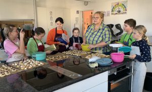 Mehr über den Artikel erfahren Begeisterte Kinder beim Gutsla-Backen